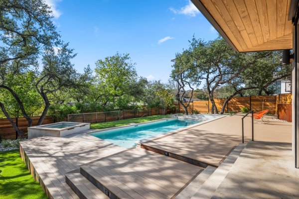 West 35th - Our West 35th project is the epitome of sophistication and family-friendly bliss! Focused on crafting a kid-centric haven, our design team diligently curated a functional and enjoyable low-maintenance yard for our client's large family. AZEK Cool Touch composite decking paves the way towards the terraced lueder stone walkway, lit with integrated lighting for safety. The pet-friendly artificial turf is leveled up, giving kids ample space to roam or for poolside games. Non-invasive bamboo and native/adapted plants give additional privacy and greenery, and the larger turf lawn provides the much-needed space for kids to be kids! Innovative screening with fig ivy will provide another green backdrop, concealing the pool equipment from view. Our design and installation team seamlessly handled aspects such as privacy, steep slopes, and working around existing trees from concept through construction, resulting in this stunning finished product. We’re sure that your yard has untapped potential—let us unveil the possibilities!