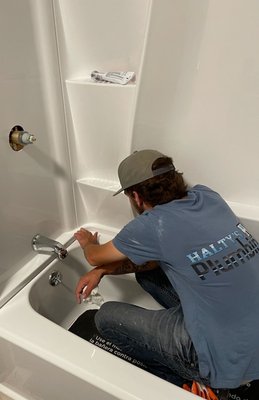Bathroom Remodel - Alec inspecting the seal on a new tub shower module being installed.
