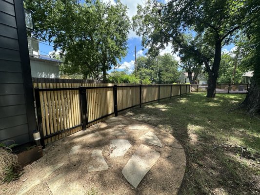 Custom Steel Frame with 2in. x 2in. Pine Pickets and Custom Walk Gate - Our customer wanted us to build a fence along their curved driveway to match the front-facing fence. We were able to match the black steel and treated pine pickets and build a fence that fully contoured the driveway. We also custom-welded a 4'W walk gate and installed it on self-closing hinges, latching with a gravity latch. Custom Steel Frame with 2in. x 2in. Pine Pickets and Custom Walk Gate - Our customer wanted us to build a fence along their curved driveway to match the front-facing fence. We were able to match the black steel and treated pine pickets and build a fence that fully contoured the driveway. We also custom-welded a 4'W walk gate and installed it on self-closing hinges, latching with a gravity latch.