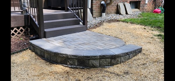 Deck landing - This customer needed a landing off the last step! That was no problem for Howell Hardscape. We incorporated a small retaining wall and Unilock brick pavers to create a perfect landing.