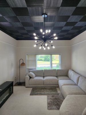 Living Room Upgrade - This living area was converted from a garage. The ceiling and wall panels were outdated and dingy. This project entailed quite a bit of prep work. There was extensive caulking required around the crown molding and base trim. This particular projected required a solid primer coat on the ceiling. Three coats of black paint were applied after the primer. Two coats of paint were applied to the walls, and trim. Living Room Upgrade - This living area was converted from a garage. The ceiling and wall panels were outdated and dingy. This project entailed quite a bit of prep work. There was extensive caulking required around the crown molding and base trim. This particular projected required a solid primer coat on the ceiling. Three coats of black paint were applied after the primer. Two coats of paint were applied to the walls, and trim.