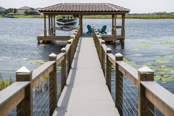 Custom Boat Dock with L-shape Roof - This custom design boat dock was a new construction build with the goal of entertainment and everyday functionality. The L-shape tile roof provides protection for your boat along with a covered activity deck with an uncovered portion. This design is perfect for a seating area in the shade or in the sun. Custom Boat Dock with L-shape Roof - This custom design boat dock was a new construction build with the goal of entertainment and everyday functionality. The L-shape tile roof provides protection for your boat along with a covered activity deck with an uncovered portion. This design is perfect for a seating area in the shade or in the sun.