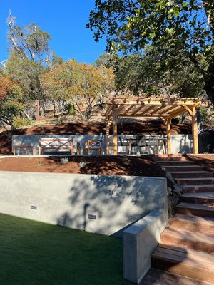 Kentfield new construction - This backyard remodel consisted of leveling & grading, artificial turf, lighting, landscape, irrigation, drainage, planters, steps, pergola, fire pit, concrete retaining walls, and upper patio. Kentfield new construction - This backyard remodel consisted of leveling & grading, artificial turf, lighting, landscape, irrigation, drainage, planters, steps, pergola, fire pit, concrete retaining walls, and upper patio.