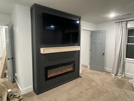 Fireplace and mantel - 🔥 Custom Accent Wall + Fireplace Install

I built this entire feature wall from scratch — custom vertical-panel accent wall, handcrafted mantel, fully installed electric fireplace, TV mount, and all new hidden electrical. A clean, modern upgrade that adds style and value to the room.