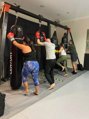 KB-FIT KICKBOXING FITNESS - That’s right!  We are now offering Kickboxing BASED fitness classes right here at Team NHBJJ!    

Blending western boxing, Muay Thai kickboxing, plyometric conditioning, and strength based movements in an exciting and ever-changing class that will surely push your cardio to the next level!  Class consists of: A brief warm-up,  6 total 5 minute rounds (3 on the bags and 3 on the floor area), and a cool down/stretch and close out.  While on the bags your instructor will call out multiple combos mixing in speed and power for a NON STOP 5 minute STRIKING ROUND! While on the floor you can expect to see fitness based stations such as: air squats, push-ups, burpees (DON’T WORRY! We don’t like them either), agility ladder, box step ups and more! Each 5 minute round is followed by a 1 min REST PERIOD… Trust us, you’ll need it!