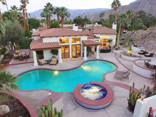 "CASA BLANCA" 4 Bedrooms 4.5 Baths, Max Occupancy 8 Guests - For more information and to request a reservation quote for your date range, visit
https://www.pdvacationrentals.com/casablanca.
Behind the walls of this beautiful La Quinta estate you will find a private compound set on a 3/4 acre lot surrounded by mountains and palm trees.
The property features a 3574 square foot main house with 3 bedrooms, 3.5 bathrooms, full wet bar and office.
The 800 square foot casita with en suite bath is more reminiscent of a guest house and is separated from the main house by a green belt and a rose garden with citrus trees. At the casita entrance is a large covered porch with ceiling fan and a cozy conversation area where you can enjoy a morning cup of coffee while the rest of the world is still sleeping.
Beautifully furnished, Casa Blanca is suited for any occasion and offers an easy elegant atmosphere for indoor and outdoor entertaining. The open floor plan and spaciousness of this compound is perfect for family reunions, a golfing getaway or just to reunite with old friends.
The amazing backyard sits at the foot of a mountain and includes an oversize putting green, pool with raised spa, outdoor fireplace, fire pit table and built-in gas BBQ.
Seating areas set on multi levels can be found throughout the exterior of the home including an outdoor living room with a flat screen TV. Pathways throughout the property take you from the main house to the casita as well as a 1600 sq. foot 4 car garage and private gated driveway.
Centrally located with easy access to the entire valley, Casa Blanca is surrounded by championship golf courses and is within walking distance to Old Town where you will find quaint shops, eateries and annual art festivals. Just a 10 minute drive will take you to The Indian Wells Tennis Garden which hosts the BNP Tennis Tournament each March or The Polo Grounds for the Coachella and Stagecoach music festivals in April and October.
Be forewarned...Once you enter this amazing private compound, you will have a hard time leaving the grounds for any reason. "CASA BLANCA" 4 Bedrooms 4.5 Baths, Max Occupancy 8 Guests - For more information and to request a reservation quote for your date range, visit
https://www.pdvacationrentals.com/casablanca.
Behind the walls of this beautiful La Quinta estate you will find a private compound set on a 3/4 acre lot surrounded by mountains and palm trees.
The property features a 3574 square foot main house with 3 bedrooms, 3.5 bathrooms, full wet bar and office.
The 800 square foot casita with en suite bath is more reminiscent of a guest house and is separated from the main house by a green belt and a rose garden with citrus trees. At the casita entrance is a large covered porch with ceiling fan and a cozy conversation area where you can enjoy a morning cup of coffee while the rest of the world is still sleeping.
Beautifully furnished, Casa Blanca is suited for any occasion and offers an easy elegant atmosphere for indoor and outdoor entertaining. The open floor plan and spaciousness of this compound is perfect for family reunions, a golfing getaway or just to reunite with old friends.
The amazing backyard sits at the foot of a mountain and includes an oversize putting green, pool with raised spa, outdoor fireplace, fire pit table and built-in gas BBQ.
Seating areas set on multi levels can be found throughout the exterior of the home including an outdoor living room with a flat screen TV. Pathways throughout the property take you from the main house to the casita as well as a 1600 sq. foot 4 car garage and private gated driveway.
Centrally located with easy access to the entire valley, Casa Blanca is surrounded by championship golf courses and is within walking distance to Old Town where you will find quaint shops, eateries and annual art festivals. Just a 10 minute drive will take you to The Indian Wells Tennis Garden which hosts the BNP Tennis Tournament each March or The Polo Grounds for the Coachella and Stagecoach music festivals in April and October.
Be forewarned...Once you enter this amazing private compound, you will have a hard time leaving the grounds for any reason.