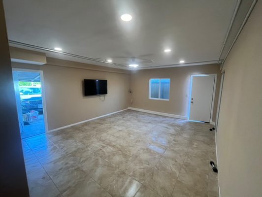 Garage to living space conversion - This was a project where we previously converted a garage to a living space. We built a wall covering the view of the garage door but still giving the client access to open and close it. We also painted all the walls and doors added a window on the exterior side wall added recessed lighting and put down a tile floor. Garage to living space conversion - This was a project where we previously converted a garage to a living space. We built a wall covering the view of the garage door but still giving the client access to open and close it. We also painted all the walls and doors added a window on the exterior side wall added recessed lighting and put down a tile floor.