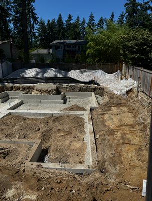 Kirkland Adult Care Facility - This project involved transforming an existing single-family home into an 8-unit adult care facility. All Terrain Contractors provided full site development services from start to finish, including foundation excavation, installation of footing drains, downspout lines, catch basins, and complete sewer and water systems. Our team also performed ROW utility tie-ins to the city storm main and handled all final grading for a clean, build-ready finish. The result — a precise, code-compliant foundation and site that set the stage for a seamless vertical build in the heart of Kirkland. Kirkland Adult Care Facility - This project involved transforming an existing single-family home into an 8-unit adult care facility. All Terrain Contractors provided full site development services from start to finish, including foundation excavation, installation of footing drains, downspout lines, catch basins, and complete sewer and water systems. Our team also performed ROW utility tie-ins to the city storm main and handled all final grading for a clean, build-ready finish. The result — a precise, code-compliant foundation and site that set the stage for a seamless vertical build in the heart of Kirkland.