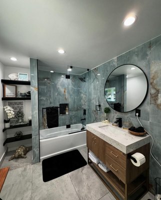 Bathroom Remodel - This fully transformed bathroom showcases stunning blue-gray marble walls, a modern glass-enclosed shower, and a sleek vanity with a quartz countertop, creating a sophisticated and elegant ambiance. The large circular mirror and black fixtures add a bold touch, while custom shelving provides both style and functionality. Every detail has been thoughtfully designed to create a serene, luxurious retreat.
Call TODAY for a FREE estimate!!
833.717.7742 Bathroom Remodel - This fully transformed bathroom showcases stunning blue-gray marble walls, a modern glass-enclosed shower, and a sleek vanity with a quartz countertop, creating a sophisticated and elegant ambiance. The large circular mirror and black fixtures add a bold touch, while custom shelving provides both style and functionality. Every detail has been thoughtfully designed to create a serene, luxurious retreat.
Call TODAY for a FREE estimate!!
833.717.7742