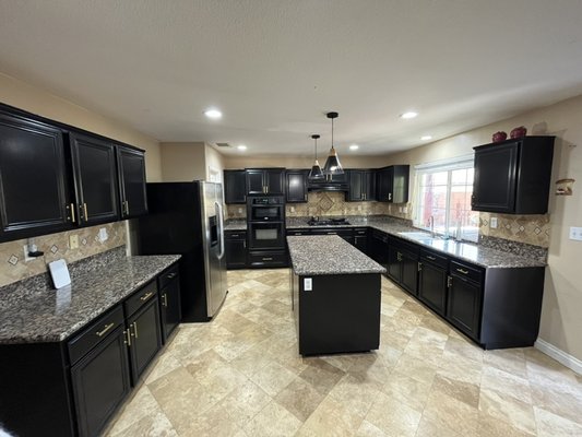 Kitchen cabinet painting - Previously stained by someone our clients reached out to us to redo their cabinets. They chose to go with a black semi gloss finish and wanted brand new handles installed.