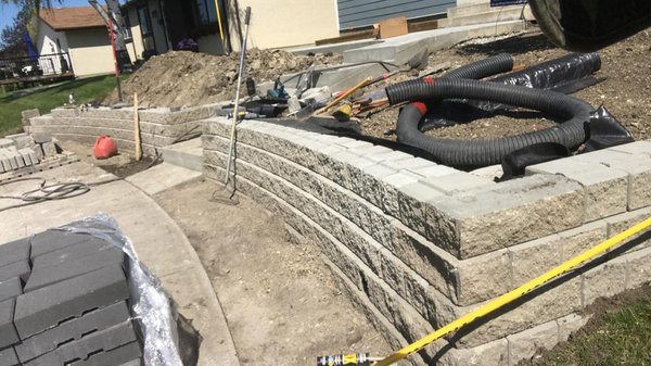 Building retaining wall on a slope - How to Retain a Steep Slope with Retaining Wall Blocks
Step 1: Design the Retaining Wall. ...
Step 2: Mark the Layout of the Wall. ...
Step 4: Set the Finish Grade. ...
Step 5: Excavate for the Base. ...
Step 6: Install the Base Material. ...
Step 7: Set the Base Course. ...
Step 8: Set Additional Courses. ...
Step 9: Add Retaining Wall Caps. Building retaining wall on a slope - How to Retain a Steep Slope with Retaining Wall Blocks
Step 1: Design the Retaining Wall. ...
Step 2: Mark the Layout of the Wall. ...
Step 4: Set the Finish Grade. ...
Step 5: Excavate for the Base. ...
Step 6: Install the Base Material. ...
Step 7: Set the Base Course. ...
Step 8: Set Additional Courses. ...
Step 9: Add Retaining Wall Caps.