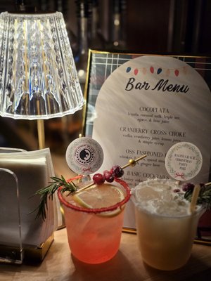 Christmas Party - We had the pleasure of providing bar service for a Brazilian Jiu-Jitsu-themed Christmas party, creating a festive and fully customized experience for the team.

We crafted three signature cocktails, each inspired by the Christmas season, but with playful jiu-jitsu-themed names, combining holiday cheer with the team’s passion. Guests enjoyed drinks served with custom drink clips featuring the team logo, adding a personal and memorable touch.

Our black mobile bar cart was styled to stand out, featuring the team’s logo prominently in front, backlit with warm lights for a striking visual effect. The custom bar menu reflected the Christmas jiu-jitsu theme, completing the cohesive and fun presentation.

Additional décor included a Christmas tree, enhancing the festive atmosphere and tying the holiday and jiu-jitsu themes together. Every detail — from cocktails and signage to lighting and themed décor — was carefully executed to create a memorable, playful, and elevated bar experience for the celebration.