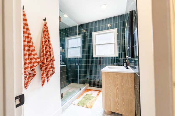 Luxury Bathroom Makeover & Shower Upgrade - Step into a spa-inspired oasis designed for comfort and style. This beautifully refreshed bathroom features sleek floor-to-ceiling emerald tile, a spacious glass-enclosed shower, and warm natural wood finishes that create the perfect balance of modern luxury and cozy charm. Bright natural light pours through the windows, highlighting every clean line and thoughtful detail. Bold, patterned accents add personality while maintaining a crisp, elevated look. Luxury Bathroom Makeover & Shower Upgrade - Step into a spa-inspired oasis designed for comfort and style. This beautifully refreshed bathroom features sleek floor-to-ceiling emerald tile, a spacious glass-enclosed shower, and warm natural wood finishes that create the perfect balance of modern luxury and cozy charm. Bright natural light pours through the windows, highlighting every clean line and thoughtful detail. Bold, patterned accents add personality while maintaining a crisp, elevated look.
