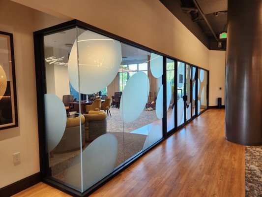 Frosted Decorative Window Film for Interior Office Glass - We recently completed a stylish decorative window film installation for a creative branding firm looking to boost office privacy without sacrificing the bright, open feel of their workspace.
The client provided custom frosted graphics featuring a circular design motif that tied into their branding. Our team installed these on 26 interior glass surfaces, covering nearly 460 square feet in total.
Here’s how the install broke down by area:
Leasing Office – 11 panels (approx. 217 sq. ft.)
Conference Room – 5 panels (approx. 99 sq. ft.)
Management Offices – 10 panels (approx. 143 sq. ft.)
Most of the panels were full-height, so precise alignment and edge-to-edge continuity were key. Our installers completed the entire project in just two days, keeping disruption to the client’s operations to a minimum.
This type of frosted film is perfect for commercial interiors—it adds a polished look, creates subtle boundaries, and reinforces brand presence, all while maintaining light and visibility.
Interested in transforming your office with custom film? We’d love to discuss options. Frosted Decorative Window Film for Interior Office Glass - We recently completed a stylish decorative window film installation for a creative branding firm looking to boost office privacy without sacrificing the bright, open feel of their workspace.
The client provided custom frosted graphics featuring a circular design motif that tied into their branding. Our team installed these on 26 interior glass surfaces, covering nearly 460 square feet in total.
Here’s how the install broke down by area:
Leasing Office – 11 panels (approx. 217 sq. ft.)
Conference Room – 5 panels (approx. 99 sq. ft.)
Management Offices – 10 panels (approx. 143 sq. ft.)
Most of the panels were full-height, so precise alignment and edge-to-edge continuity were key. Our installers completed the entire project in just two days, keeping disruption to the client’s operations to a minimum.
This type of frosted film is perfect for commercial interiors—it adds a polished look, creates subtle boundaries, and reinforces brand presence, all while maintaining light and visibility.
Interested in transforming your office with custom film? We’d love to discuss options.