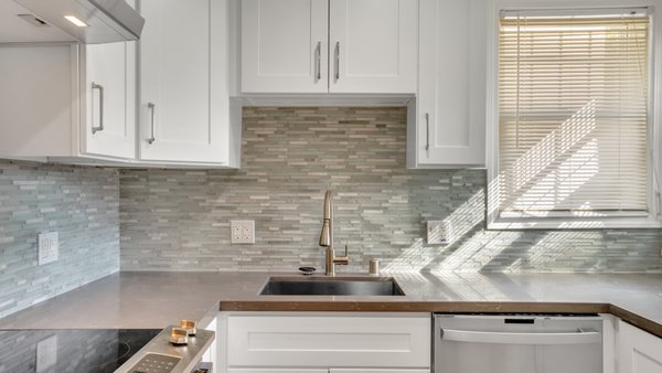 Coastal White Kitchen Remodel - A bright coastal kitchen remodel featuring crisp white cabinetry, updated countertops, a textured tile backsplash, modern lighting, and stainless-steel appliances. The layout was thoughtfully updated to maximize storage, functionality, and natural light while creating a clean, timeless space with a relaxed coastal feel. Coastal White Kitchen Remodel - A bright coastal kitchen remodel featuring crisp white cabinetry, updated countertops, a textured tile backsplash, modern lighting, and stainless-steel appliances. The layout was thoughtfully updated to maximize storage, functionality, and natural light while creating a clean, timeless space with a relaxed coastal feel.