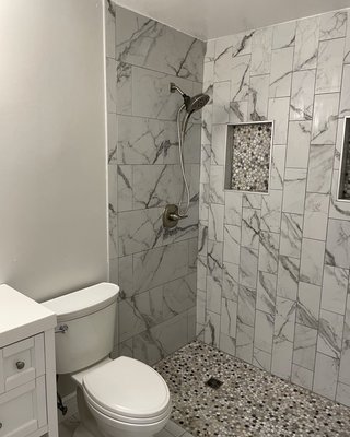 Curbless wheelchair accessible shower - By eliminating the cabinet over the encloser we gained 24 inches of ceiling height and really opened this space up. The shower curb was eliminated and the floor reconstructed for easy wheelchair access. Double niches, Natural stone pebble mosaic to shower floor and niches. Curbless wheelchair accessible shower - By eliminating the cabinet over the encloser we gained 24 inches of ceiling height and really opened this space up. The shower curb was eliminated and the floor reconstructed for easy wheelchair access. Double niches, Natural stone pebble mosaic to shower floor and niches.