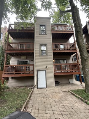 Deck Renewal: Power Wash & Stain - This three-flat deck underwent a professional power wash to eliminate years of built-up dirt and grime. We followed with a premium stain application to ensure long-lasting protection and a beautiful finish. Cleaned. Stained. Protected. This three-flat deck now shines with renewed life and long-lasting durability.