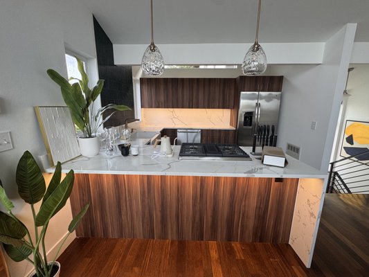 Kitchen Remodel Seattle - Kitchen Remodel Seattle — A stunning kitchen renovation featuring warm wood cabinetry, a green tile backsplash, and breathtaking natural stone countertops. This Seattle kitchen blends modern elegance with organic textures for a timeless and inviting space.