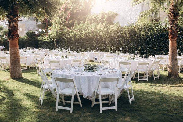 Outdoor Wedding - A versatile seating option featuring a classic white finish and comfortable padded seat. Its durable resin construction makes it ideal for weddings, corporate events, or backyard gatherings.