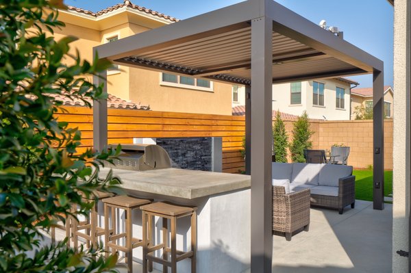 Modern outdoor kitchen vibes - This build is located in the city of Irvine in a new construction tract. We assisted the homeowner with the development of the concept and the submission to the HOA community. As usual, we took care of all the permitting, engineering, and inspections needed for this project to come to life.
Our team framed and poured the entire concrete, as well as laid the artificial grass. We constructed a modern outdoor kitchen area, as well as, a custom spill-over water feature. We installed accent walls along the perimeter. This project features plants that we hand selected, as well as, a
a state of the art smart patio cover. Modern outdoor kitchen vibes - This build is located in the city of Irvine in a new construction tract. We assisted the homeowner with the development of the concept and the submission to the HOA community. As usual, we took care of all the permitting, engineering, and inspections needed for this project to come to life.
Our team framed and poured the entire concrete, as well as laid the artificial grass. We constructed a modern outdoor kitchen area, as well as, a custom spill-over water feature. We installed accent walls along the perimeter. This project features plants that we hand selected, as well as, a
a state of the art smart patio cover.