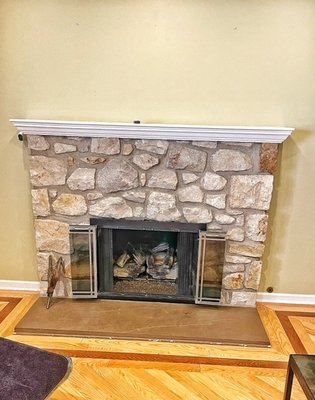 Fireplace Remodel - We love showcasing recent customer projects. In this project we removed the mantel and the stone from the original fireplace facade. We countersunk the hearth so that it was level with the flooring installation and installed a new gas log set. This fireplace has custom granite mantel and surround.