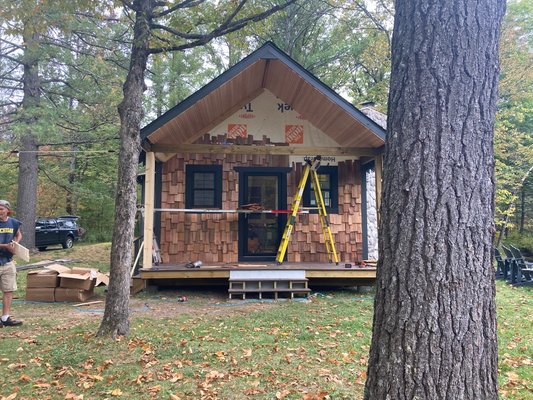 Octagon cottage on the PM river - New addition with split log siding. Newly installed deck with cedar shake siding. Paired with new stain and new roof,converted this old log cabin by the river into something of a show piece