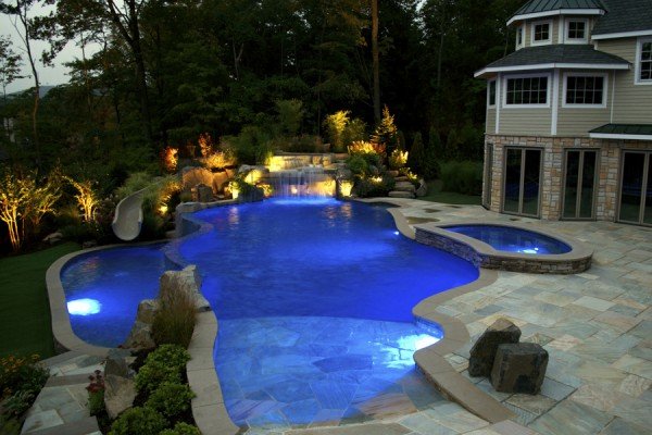 Pool - Looking for a way to transform your backyard into a luxury retreat? Check out this stunning custom pool installation!
From the modern beach-entry design to the integrated waterfall and slide, this project was all about creating a resort-style experience at home. The custom stonework and vibrant blue LED lighting make this space perfect for evening relaxation or hosting the ultimate summer party.