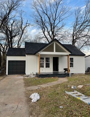 Full Exterior Paint Job - This house got a full exterior paint job using a black and white color palette with a wood-stained finish giving it a modern, sophisticated look that blends clean contrast with natural warmth.