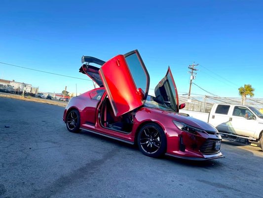 Scion TC APR Carbon Fiber Wing & Vertical Doors Installation - Our customer wanted us to install an APR Carbon Fiber wing but wanted to retain the duckbill wing with it so we fabricated it to fit the APR brackets. We also installed Vertical Doors & fabricated the fenders for the doors to open properly.