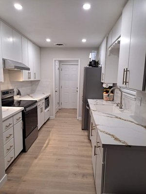 A kitchen to remember - Bold countertop, custom cabinet doors and drawers, luxurious champagne bronze trim