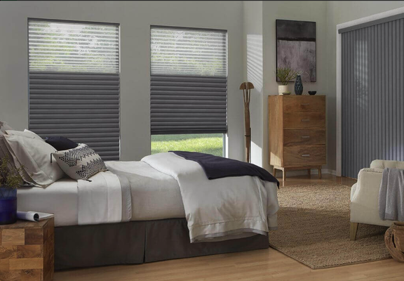 Black out drapes with honeycomb shades - Finding it challenging to balance natural light, privacy, and energy efficiency? Our premium collection of cellular, roller, Roman, and woven shades provides the perfect solution. Enhance your living space with shades designed to meet your unique needs.  This is a primary bed with black out drapes and filtering honeycomb cell shades