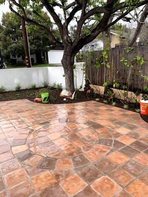 Outdoor tile installation, terracotta Ceramic Tile - We transformed this yard using porcelain terracotta tile, installing a new patio and walkway with proper compaction, drainage, and a clean staggered layout. Final touches included fresh planting and border work to tie the new hardscape into the landscape.