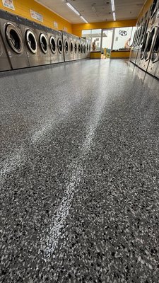 Epoxy flooring for laundry - Project features a newly installed epoxy flooring designed to enhance functionality, durability, and aesthetic appeal in commercial laundry spaces. This flooring solution is perfect for high-traffic areas like laundromats, where the floor is constantly exposed to heavy loads, water, and cleaning agents.

Key Features of the Project:

	1.	Durability and Wear Resistance: Epoxy flooring is highly durable and ideal for commercial laundromats. It withstands daily wear and tear from heavy washing machines and constant foot traffic, ensuring a long-lasting solution.
	2.	Water and Chemical Resistance: The epoxy surface is non-porous and resistant to water, detergents, and chemicals, making it easy to maintain a clean and hygienic environment.
	3.	Anti-Slip Properties: The flooring’s specialized texture provides excellent grip, preventing slips and ensuring safety for both customers and staff, even in wet conditions.
	4.	Modern Aesthetic: The smooth, sleek finish with reflective accents adds a modern touch to the space. Available in various colors and textures, this flooring can be customized to match the overall design of your facility.
	5.	Easy Maintenance: The surface is easy to clean and requires minimal upkeep, reducing time and costs associated with regular maintenance. Dirt, dust, and debris can be quickly removed with standard cleaning tools.

Installation Process:

We began the project by thoroughly preparing the subfloor to ensure proper adhesion of the epoxy. Multiple layers of high-quality epoxy compound were applied to guarantee durability and longevity. A protective topcoat was then added to enhance scratch and wear resistance.

Benefits for Laundry Owners:

	•	Reduced Maintenance Costs: The durable surface minimizes the risk of floor damage, reducing the need for frequent repairs or replacements.
	•	Improved Appearance: The modern and vibrant flooring creates a positive impression on customers, enhancing the overall appeal of the facility.
	•	Increased Safety: Anti-slip properties provide a safer environment, reducing the risk of slips and falls in the laundromat.