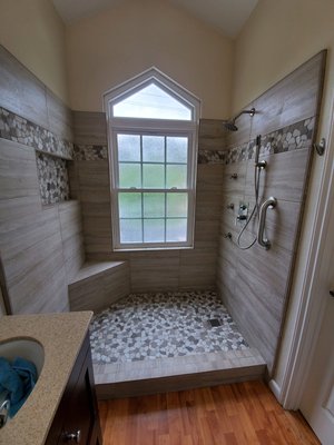 Bathtub conversion into a tiled walk-in shower. - Bathtub conversion into shower. Demo bathtub & tile enlarged shower install 12x24 porcelain tile with pebble stone shower floor. New shower system and a grab bar. New frameless shower enclosure. Bathtub conversion into a tiled walk-in shower. - Bathtub conversion into shower. Demo bathtub & tile enlarged shower install 12x24 porcelain tile with pebble stone shower floor. New shower system and a grab bar. New frameless shower enclosure.
