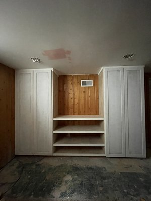 Custom Built Cabinets - These cabinets were built to conceal drain pipes that were on the exterior of a wall in a basement. The client wanted a solution that would both hide the pipes and allow for storage and possibly a TV to be set in between the cabinets. The pipes as well as their clean out locations were accurately measured to provide cabinets that fit perfectly into the space. The exterior has been left only primed as they will be painted by a professional paint crew who is also painting all the wall paneling throughout this basement. Custom built by Dollard Construction Services. Custom Built Cabinets - These cabinets were built to conceal drain pipes that were on the exterior of a wall in a basement. The client wanted a solution that would both hide the pipes and allow for storage and possibly a TV to be set in between the cabinets. The pipes as well as their clean out locations were accurately measured to provide cabinets that fit perfectly into the space. The exterior has been left only primed as they will be painted by a professional paint crew who is also painting all the wall paneling throughout this basement. Custom built by Dollard Construction Services.