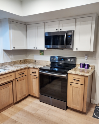 Rift-cut White Oak and White Shaker Kitchen Cabinet Refacing - This kitchen refacing project replaced our client's 90s honey oak cabinets with modern made-in-America shaker doors. They chose a beautiful rift cut white oak for the lower doors, drawers, and 1/4" wood panels and a pale dove gray color for the upper cabinets and wood panels.