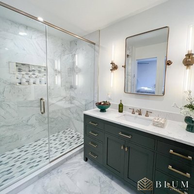 Thousand Oaks Master Bathroom Remodel - We transformed this master bathroom into a refined, spa-inspired retreat. The new layout features floor-to-ceiling marble tile, a frameless glass shower enclosure with patterned mosaic flooring, and brushed brass fixtures throughout. Custom green shaker cabinetry paired with brass hardware brings a rich contrast to the soft white palette, while double vertical sconces and a floating brass-framed mirror add an elegant touch. Every element—from lighting to tile selection—was curated to create a timeless, elevated space for daily use. Thousand Oaks Master Bathroom Remodel - We transformed this master bathroom into a refined, spa-inspired retreat. The new layout features floor-to-ceiling marble tile, a frameless glass shower enclosure with patterned mosaic flooring, and brushed brass fixtures throughout. Custom green shaker cabinetry paired with brass hardware brings a rich contrast to the soft white palette, while double vertical sconces and a floating brass-framed mirror add an elegant touch. Every element—from lighting to tile selection—was curated to create a timeless, elevated space for daily use.