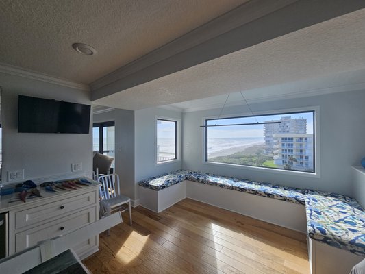 Roller Shades in 3% Before & After - One of our customers was fortunate to have a breathtaking ocean view through expansive windows—but the intense glare and harmful UV rays made the space less enjoyable, especially during peak daylight hours. Royal Shades & Blinds provided the perfect solution by installing 3% motorized roller shades. These sleek, modern shades filter sunlight without blocking the stunning coastal scenery, allowing the natural beauty to shine through while significantly reducing glare and UV exposure. With the convenience of motorization, adjusting light levels throughout the day is effortless. Now, the dining area has been transformed into a comfortable, sun-protected space where the customer can sit back, enjoy meals, and take in the ocean view without compromise.