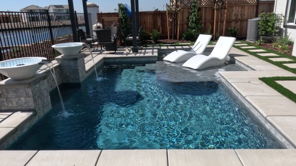 Kiper Homes "Capri models" River Islands, Lathrop - Model home display pool at Kiper Homes' "Capri" in River Islands, Lathrop, CA. 🏠💦 This stunning pool showcases beautiful opal-shaded water bowls 🌊💧, a relaxing Baja shelf for lounging 🏖️, and a sophisticated dove grey shimmer interior finish ✨. It’s the seventh model pool that Aquos Pools has designed and built for Kiper in their Tri-Valley subdivisions. 🌟🏊‍♂️ We’re proud to continue our collaboration and create exceptional outdoor spaces that enhance every home.