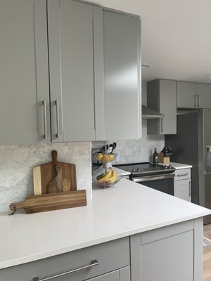 Isabella Designs. - Budget friendly Project. Counter tops installed and materials supplied, with beautiful waterfall panels Stoneworld Seattle.  Marble backsplash supplied Stoneworld Seattle. Isabella design supplied cabinets.