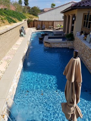 Small Backyard Wonder - This project takes up almost the entire backyard.  It has many unique features.  There is a wooden sunken seating area inside the pool.  The water from the pool spills over the walls of the seating area and sucked back into the pool with an extra pump.  The fire bowls add a nice flair to the pool.