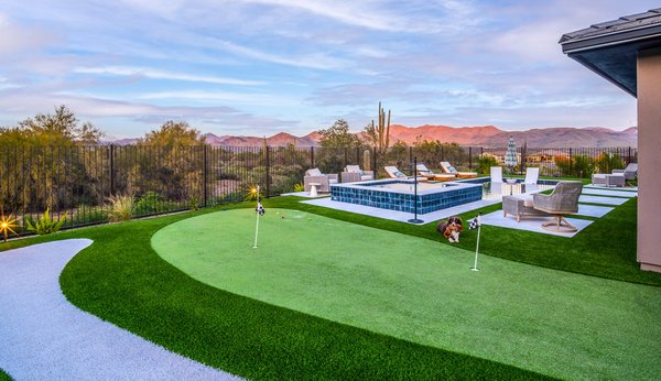 Backyard Installation at Trilogy - Backyard installation with a custom concrete counter BBQ island, a custom putting green, artificial turf and travertine pool deck. Beautiful views with a beautiful landscape installation to compliment the exterior desert landscape at Trilogy. Backyard Installation at Trilogy - Backyard installation with a custom concrete counter BBQ island, a custom putting green, artificial turf and travertine pool deck. Beautiful views with a beautiful landscape installation to compliment the exterior desert landscape at Trilogy.