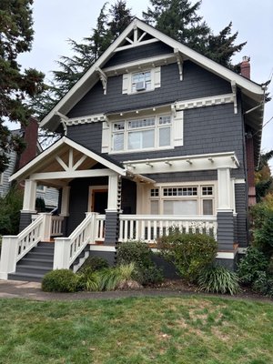 Irvington Front Porch Rebuild - 2024 - This historic Irvington home was suffering from a poorly executed remodel that did not reflect the original character and intent of the building. We removed all of the rotting siding from the columns, the arbor, the millwork details, the porch floor, and the stairs.
Through careful reconstruction and attention to detail, we rebuilt the columns, installed new fir flooring, more period appropriate millwork, and a clear roof over the arbor. With an eye to preventing future water intrusion, all flashing details and methods of preventing water intrusion were employed.
The result was a gorgeous reimagining of the builder's original intent, with the benefit of modern techniques to mitigate water infiltration, provide a covered porch area that allowed light to enter the front picture window, a lustrous refinished fir floor, and a new gutter and downspout system that incorporated a rain chain for a final grace note. Irvington Front Porch Rebuild - 2024 - This historic Irvington home was suffering from a poorly executed remodel that did not reflect the original character and intent of the building. We removed all of the rotting siding from the columns, the arbor, the millwork details, the porch floor, and the stairs.
Through careful reconstruction and attention to detail, we rebuilt the columns, installed new fir flooring, more period appropriate millwork, and a clear roof over the arbor. With an eye to preventing future water intrusion, all flashing details and methods of preventing water intrusion were employed.
The result was a gorgeous reimagining of the builder's original intent, with the benefit of modern techniques to mitigate water infiltration, provide a covered porch area that allowed light to enter the front picture window, a lustrous refinished fir floor, and a new gutter and downspout system that incorporated a rain chain for a final grace note.
